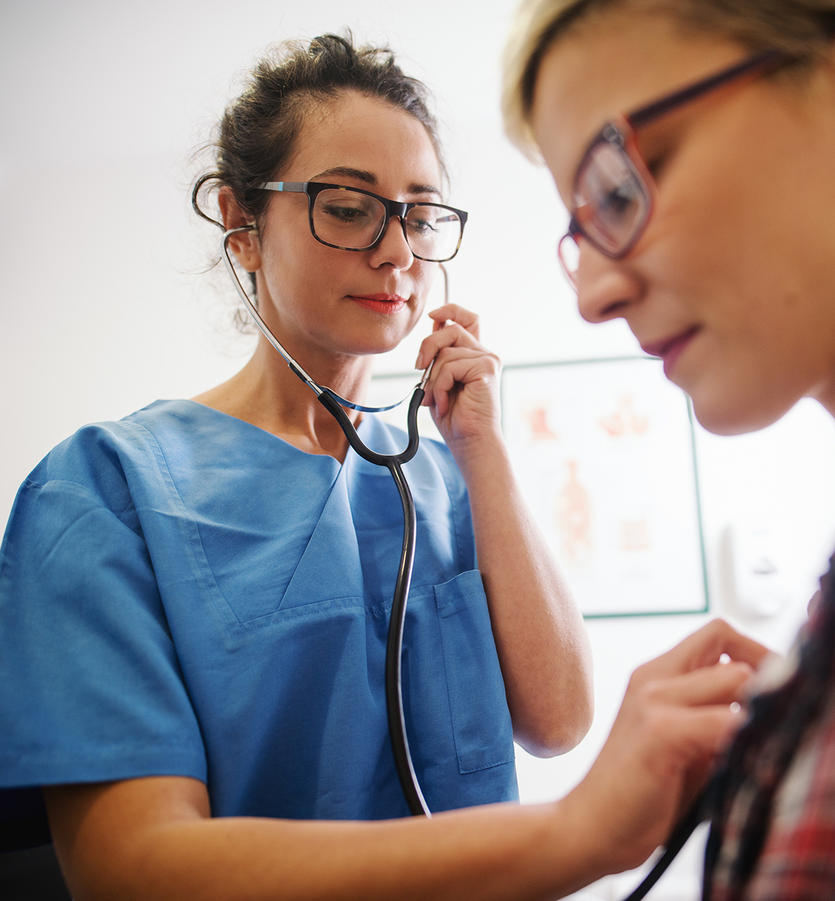 Female middle-aged doctor using stethoscope to examine patient.